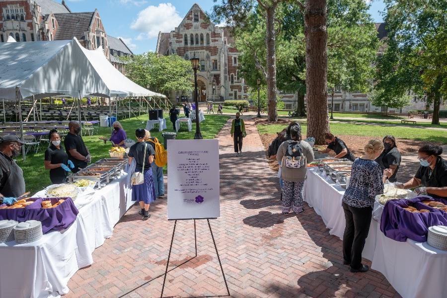 attendees of new student orientation wait for food to be served in the tent on the Main quad